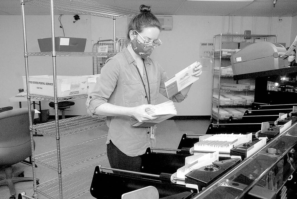 Keith Thorpe/Peninsula Daily NewsClallam County election worker Nicole Mischke pulls sorted ballots from a sorting machine on Wednesday at the county courthouse in Port Angeles. County Auditor Shoona Riggs said Wednesday that they have received about 20,000 ballots out of almost 57,000 sent to registered voters.