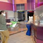 Deer Park Cinema manager Casey Chapman sprays disinfectant mist around the concession stand of the Port Angeles theater complex lobby Thursday, Oct. 22, in preparation for reopening Oct. 30. (Photo by Keith Thorpe/Olympic Peninsula News Group