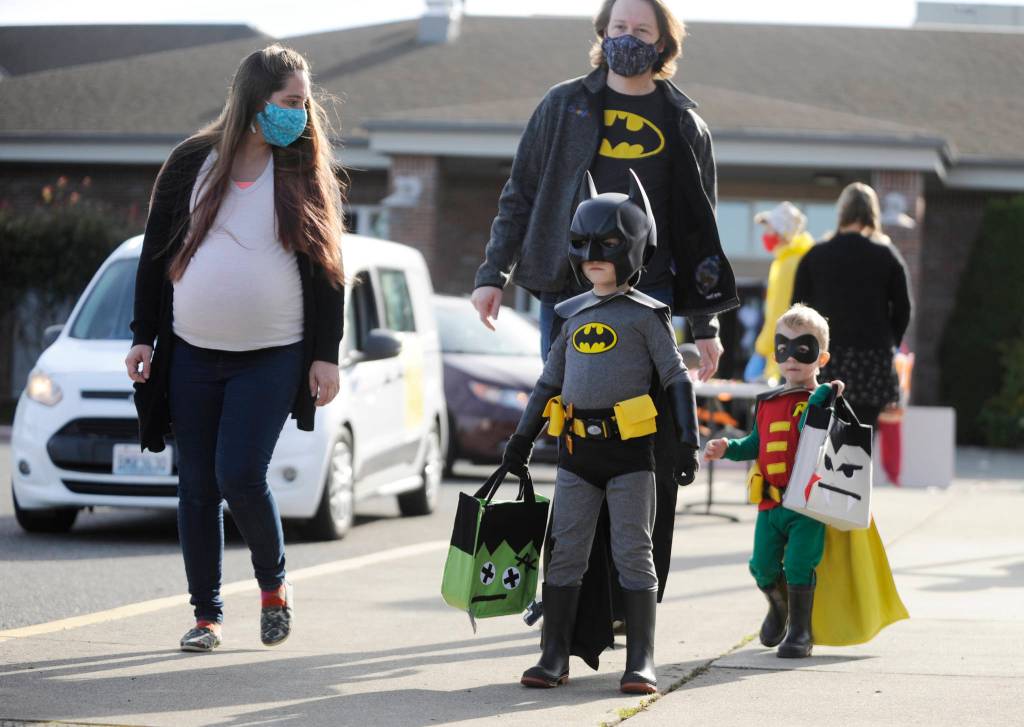 The Dynamic Duo of Batman and Robin (Truman, 5, and Archer, 2), accompanied by parents Luke and Aubrey Leishman of Sequim, enjoy some trick-or-treating at the Sequim High Schools Halloween event, modified this year for drive-thru and walk-thru guests. Sequim Gazette photos by Michael Dashiell