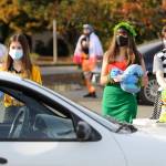 From left, Sequim High School students Alliyah Weber, Christina Caples and Delaney Nucci hand out candy at SHSs drive-thru Halloween event on Oct. 31.