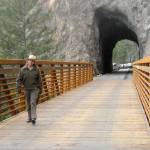 Olympic National Park Superintendent Sarah Creachbaum walks across a new bridge on the Spruce Railroad Trail abutting the recently renovated Daley-Rankin Tunnel at the start of a ceremony on Thursday to celebrate the soon-to-be-open trail on the north shore of Lake Crescent. (Keith Thorpe/Peninsula Daily News)