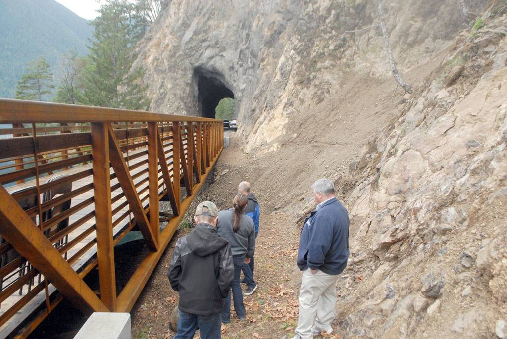 Dedication ceremony guests examine the underside of a new bridge on the Spruce Railroad Trail on Thursday. (Keith Thorpe/Peninsula Daily News)