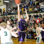 Sequims Isaiah Moore, center, puts up a shot over the Port Angeles defense in the Wolves 57-32 loss in February. State sport officials said the return of high school sports will be delayed by at least another month and all three prep seasons have been reduced by a week. Sequim Gazette file photo by Michael Dashiell