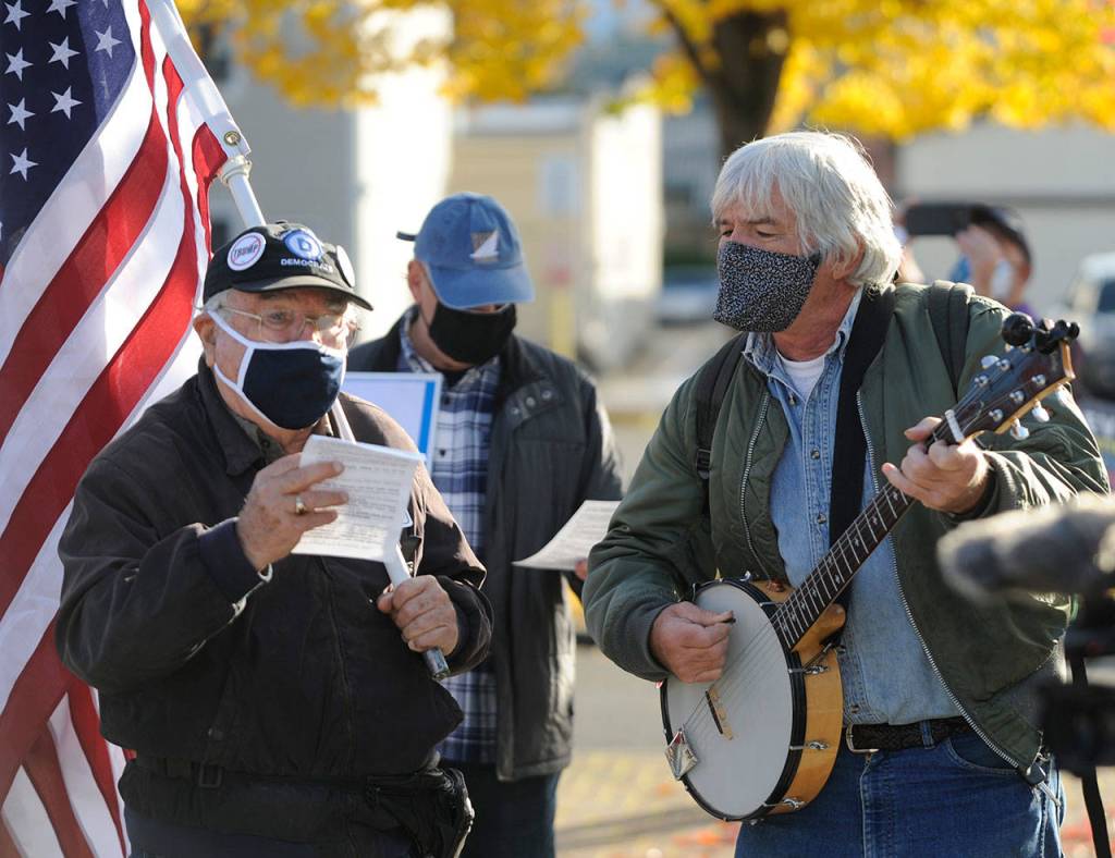 Tim Wheeler, left, and a group of about 40 individuals sing Woody Guthries This Land Is Your Land, accompanied by Steve Koehler on banjo, at the Sequim Civic Center on Nov. 4. Sequim Gazette photo by Michael Dashiell