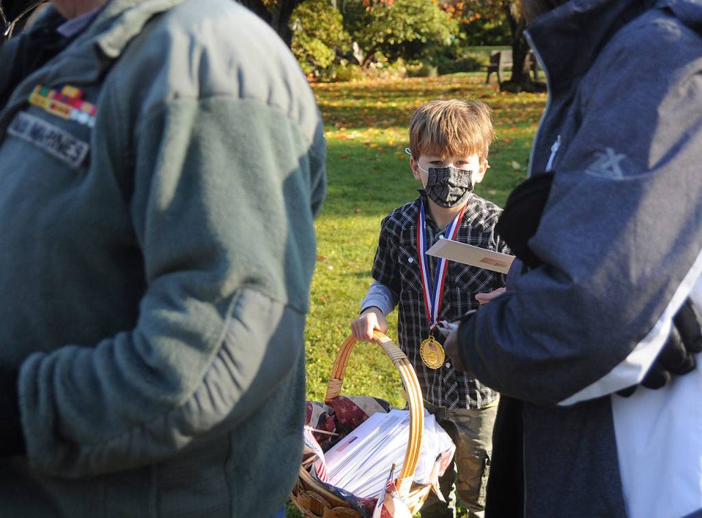 Ivan Cortani hands out tank-you cards to veterans and family members at the Nov. 11 Veterans Day event at Sequims Pioneer Memorial Park. Cortani won a raffle at the What Is a Veteran? event at the George Washington Inn t earn the chance to had out the cards created by students in first, second and third grades. Sequim Gazette photo by Michael Dashiell