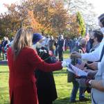 Members of the Daughters of the American Revolution-Michael Trebert Chapter hand out red, white and blue flowers to veterans and their families at Pioneer Memorial Park on nov. 11. Sequim Gazette photo by Michael Dashiell