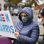 Kathy McGee and Chris Walker, both of Sequim, look at updated news on the presidential election on Nov. 7 as they rally with other community members to show their support for the election of Joe Biden and Kamala Harris. Sequim Gazette photo by Matthew Nash