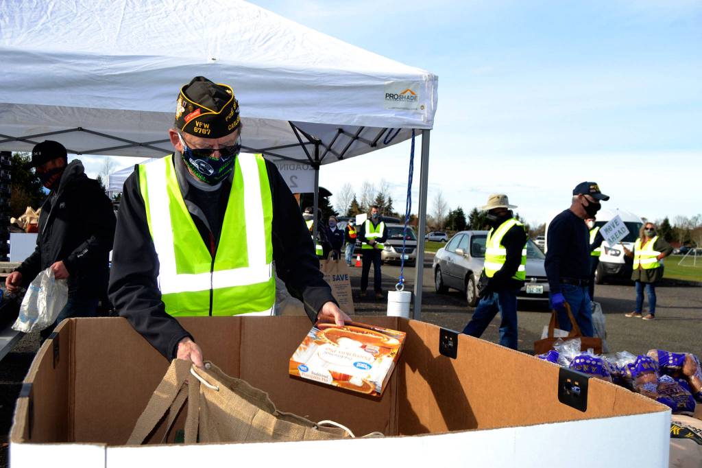 Calvin Barnard, senior vice commander of Carlsborg VFW Post 6787, places a pie in a bag for a family at the Family Holiday Meal Bay program on Nov. 20. Sequim Gazette photo by Matthew Nash