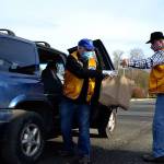 George Dooley, left, and Edward Alders with the Sequim Valley Lions Club work together to load a vehicle with food during the Family Holiday Meal Bag distribution program on Nov. 20. Dozens of volunteers like them helped load up Thanksgiving meals for 900 families. Sequim Gazette photo by Matthew Nash