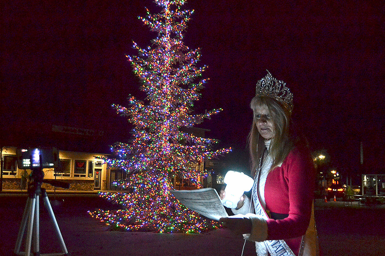 Captain-Crystal Stout sings Its beginning to look a lot like Christmas (in Sequim) to celebrate the lighting of the Sequim tree on Thanksgiving night. Sequim Gazette photo by Matthew Nash