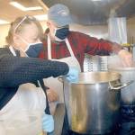 Volunteers Linda and Doug Crabb of Sequim stir pots of gravy in the Salvation Army food kitchen on Wednesday in Port Angeles. (Keith Thorpe/Peninsula Daily News)