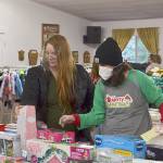 Desirae Cortez and volunteer Kirsti Turella, a first year volunteer with Toys for Sequim Kids, look for just the right toy for one of Cortezs four children. Sequim Gazette photo by Matthew Nash