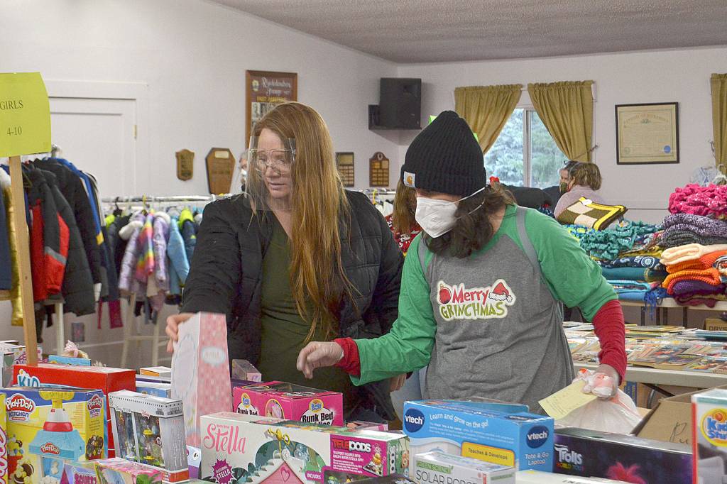 Desirae Cortez and volunteer Kirsti Turella, a first year volunteer with Toys for Sequim Kids, look for just the right toy for one of Cortezs four children. Sequim Gazette photo by Matthew Nash