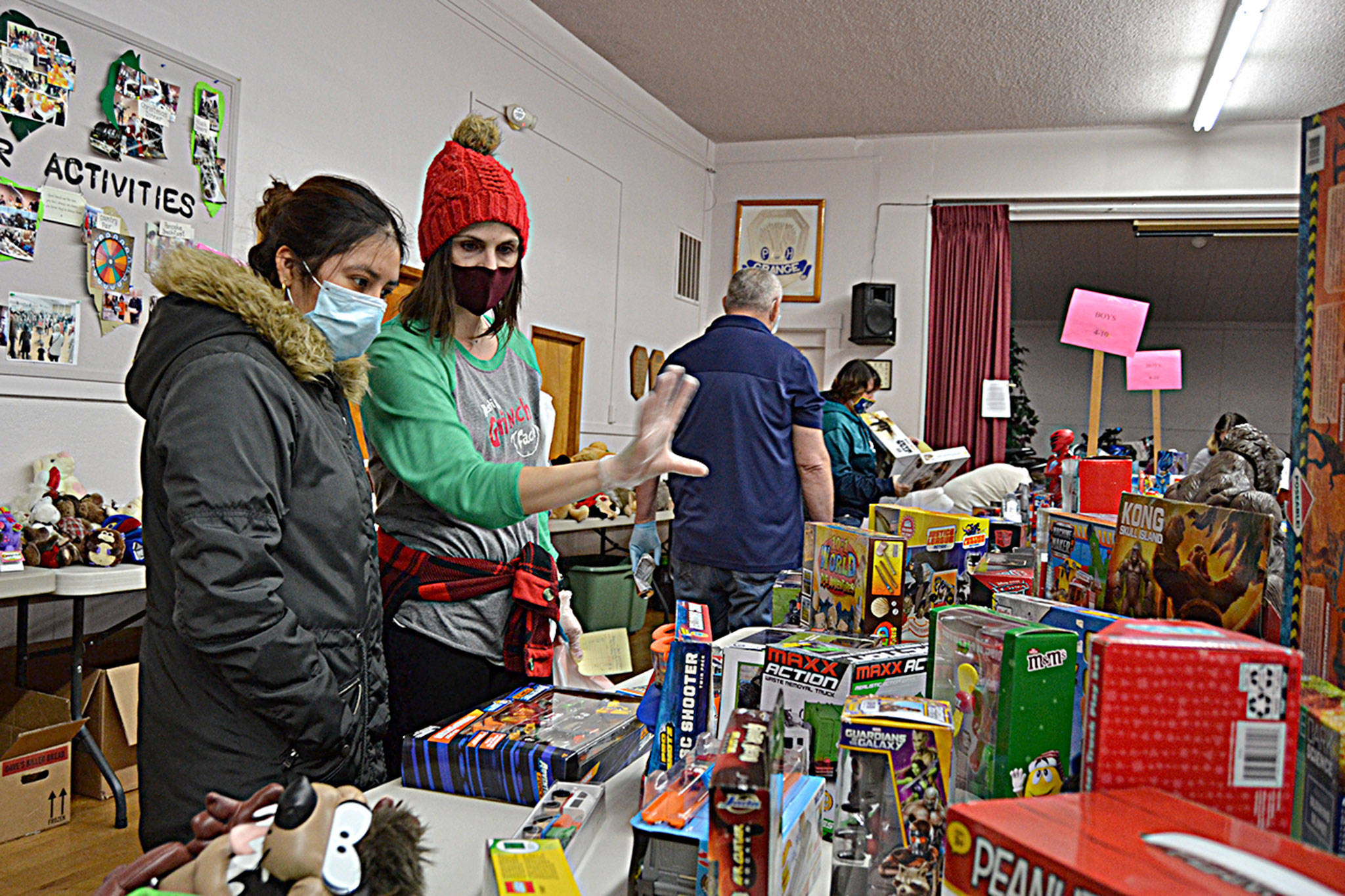 Volunteer elf Amy Pearson helps Guadarrama Quezada look for presents for her three children during the Toys for Sequim Kids event. Organizers said they saw a record amount of donations despite the pandemic in place. Sequim Gazette photos by Matthew Nash