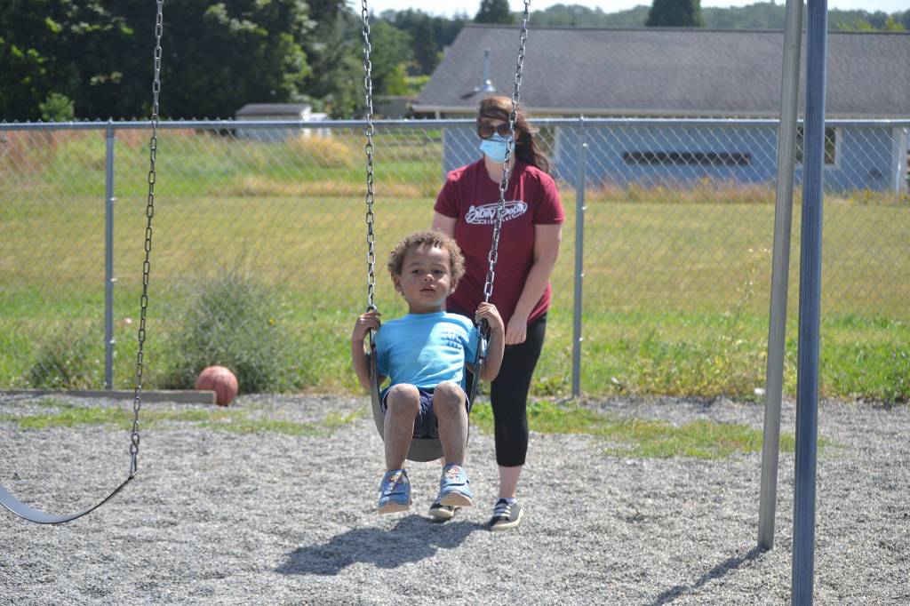 In June, Sarah Schmedding plays with Harry Piper on the swings at Bibity Bobity. Space for child care has stayed mostly the same at Bibity Bobity in Carlsborg with school-aged children being the biggest shift, says owner-director Nicole Goettling. They used to come after school but now stay all day due to distance learning in-place due to the pandemic. Sequim Gazette file photo by Matthew Nash