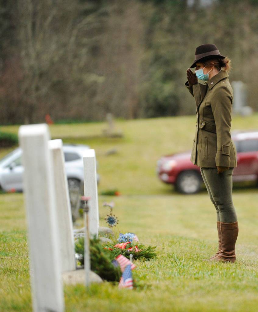 Lance Cpl. Holly Rowan, a U.S. Marine Corps veteran, salutes after laying a ceremonial wreath at Saturdays Wreaths Across America event at Sequim View Cemetery.