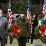 Staff Sgt. Jessica Elizalde-Broders, a U.S. Army veteran, looks to lay a ceremonial wreath at Sequim View Cemetery Saturday. In the foreground are, from left, Cmdr. Bill Benedict (U.S. Navy, ret.), Lance Cpl. Holly Rowan (U.S. Marine Corps veteran) and Cmdr. Joan Snaith (U.S. Coast Guard, Air Station Port Angeles). Sequim Gazette photo by Michael Dashiell