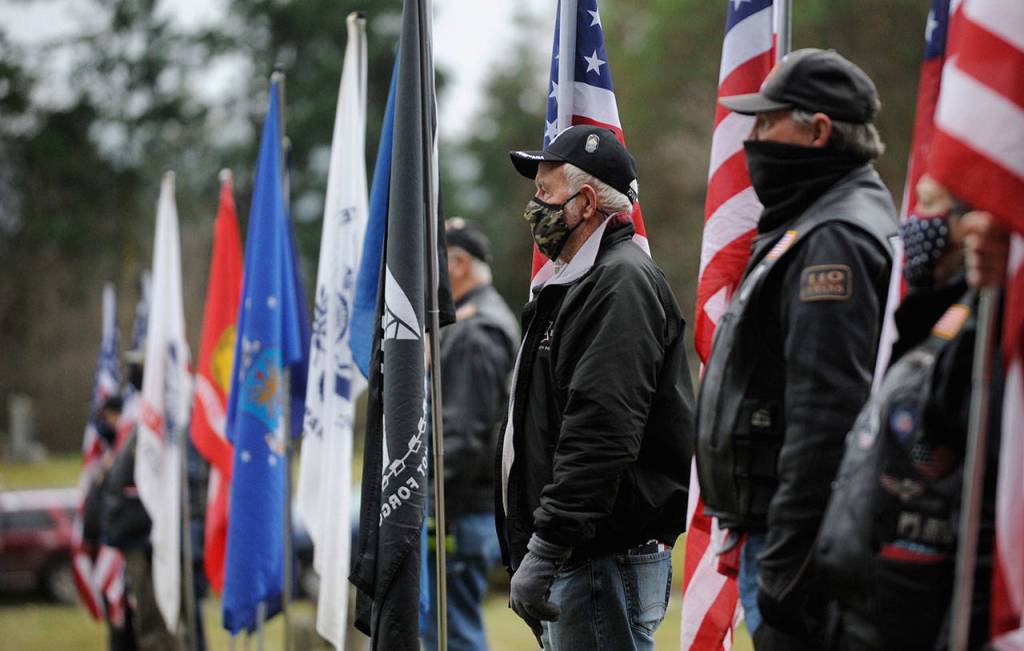 Members of the Clallam County Legion Riders Post 29 create a flag line as a patriotic backdrop to the Wreaths Across America event held Dec. 19 at Sequim View Cemetery. Sequim Gazette photo by Michael Dashiell