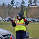 Jeffrey Hartman, a Sequim Sunrise Rotarian and Community Emergency Response Team (CERT) member, helps direct traffic on Dec. 18 to stations to pick up food for Christmas time. Hartman was one of dozens of volunteers who helped with the event. Sequim Gazette photo by Matthew Nash