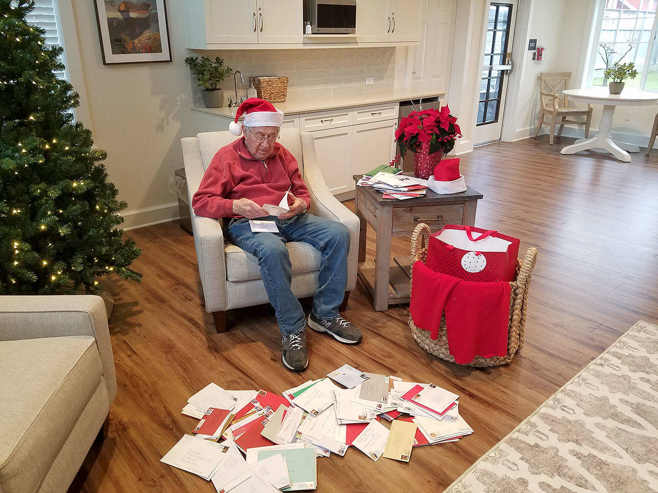 Rodney Hofman opens one of hundreds of Christmas cards sent to him and fellow Dungeness Courte Memory Care residents, following a request from Hofmans family members on social media. Photo courtesy of Dungeness Courte Memory Care