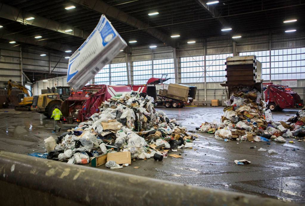 Garbage trucks dump trash onto the tipping floor at the Airport Road Recycling & Transfer Station on Nov. 24 in Everett. Photo by Olivia Vanni/The Herald (Everett)