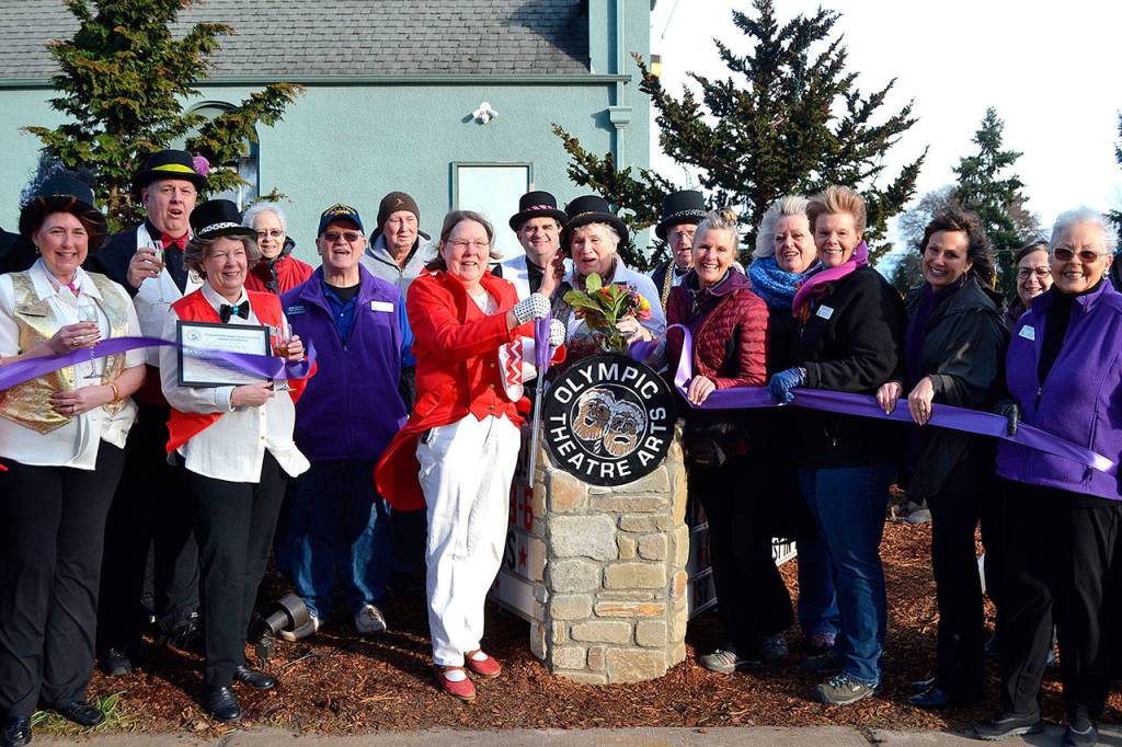 Executive Director Carol Willis, center left, cuts the ribbon for Olympic Theatre Arts new sign Feb. 1, 2020, as part of an open house with theatre supporters and members of the Sequim-Dungeness Valley Chamber of Commerce. Willis stepped down from her OTA role recently with health issues.