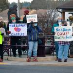 Dozens of people wave signs at the Sequim Avenue/Washington Street intersection Monday in support of Sequim city manager Charlie Bush. Sequim Gazette photo by Matthew Nash