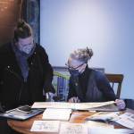 Creating a Scene exhibit curators Amy McIntyre, left, and Sarah Jane review Esther Websters historic sketchbooks in preparation for the upcoming exhibit. Photo by Kyle LeMaire-Bartholick