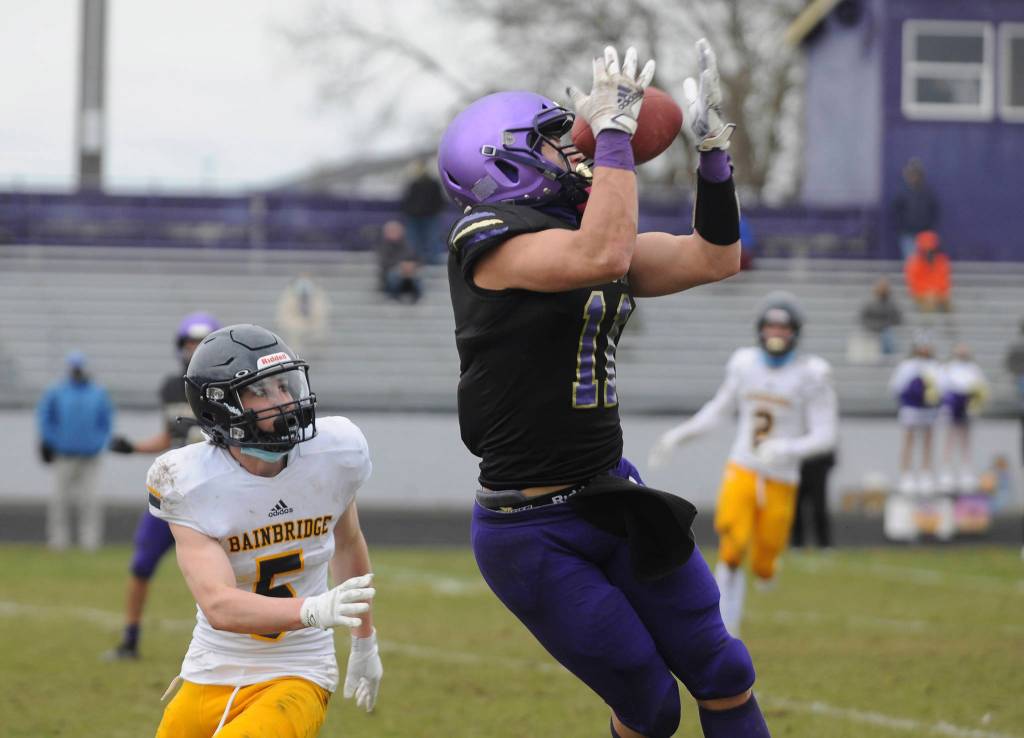Sequim senior receiver Michael Young, right, hauls in a 34-yard pass from Kobe Applegate in the second half of Sequims shutout win over Bainbridge on Feb. 20. Sequim Gazette photo by Michael Dashiell