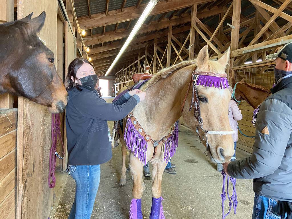 Rainey Bronsink helps the drill team get ready to compete at the Sequim Equestrian Teams first district meet in late February. Submitted photo