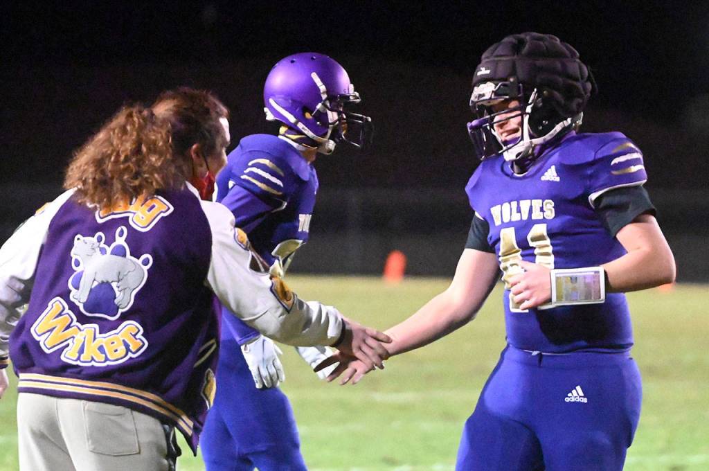 Sequim quarterback Lars Wiker, right, gets congratulations from older brother Taig after Lars tossed his first touchdown pass in the Wolves 27-15 win over South Kitsap on March 5. Sequim Gazette photo by Michael Dashiell