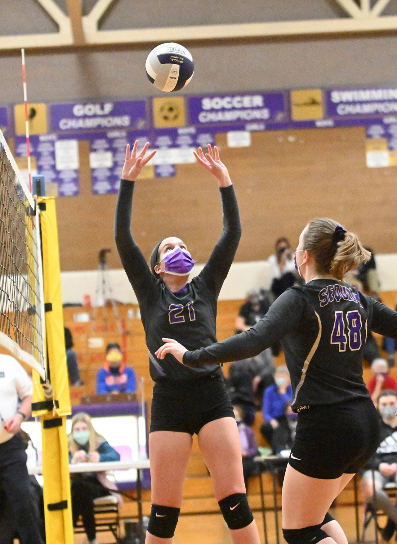 Sequims Kalli Wiker (21) looks to set Malory Morey (48) in the Wolves three-set win over Klahowya on March 8. Sequim Gazette photo by Michael Dashiell