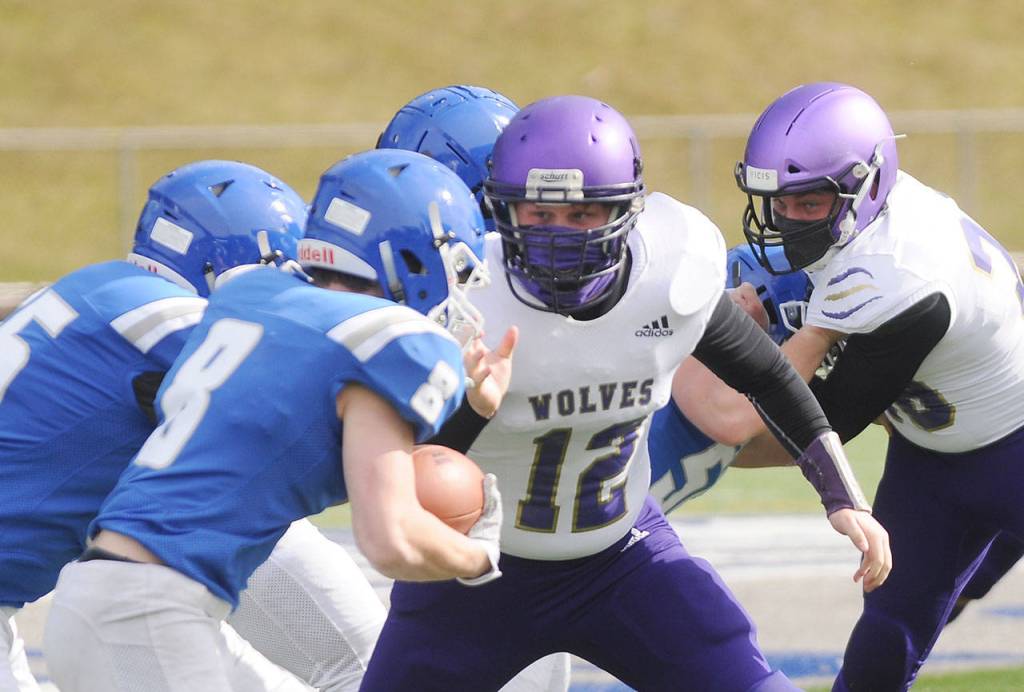 Braiden Kitchen looks to make a stop on Olympic running back Trent Feistner in the Wolves 21-12 loss at Olympic on March 13.