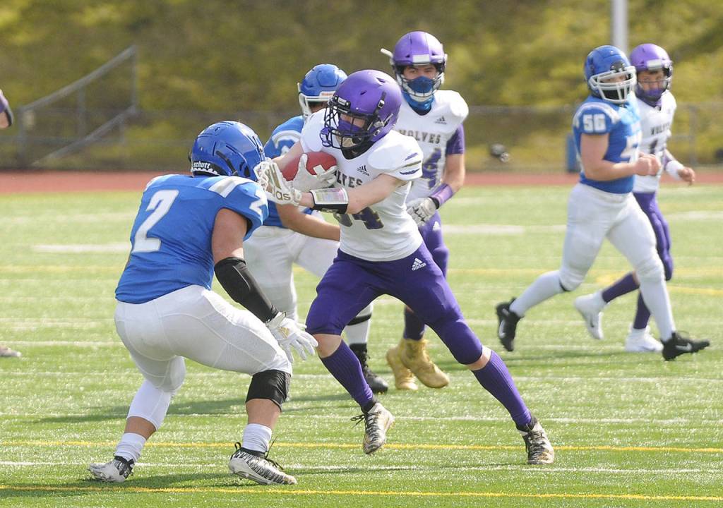 Sequim receiver Jonas Welch looks for more yardage in the first half of Sequims match-up with Olympic on March 13. Sequim Gazette photo by Michael Dashiell
