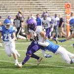 Sequim receiver Michael Young drags defenders for a big gain in the Wolves loss on March 13 at Olympic. Sequim Gazette photo by Michael Dashiell