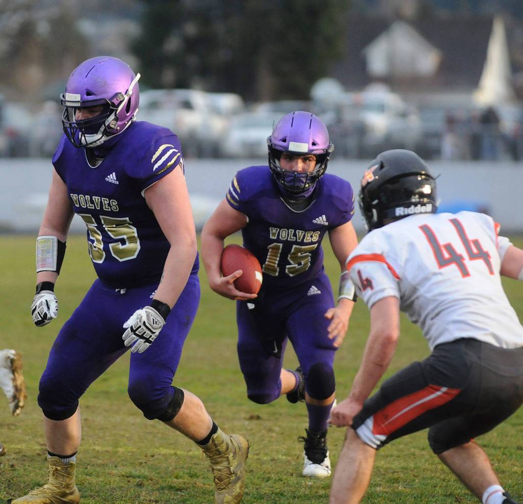 Sequim quarterback Taig Wiker gets some key blocking from Brandon Barnett (55) in the first half of Sequims season finale against Central Kitsap on March 18. Sequim Gazette photo by Michael Dashiell