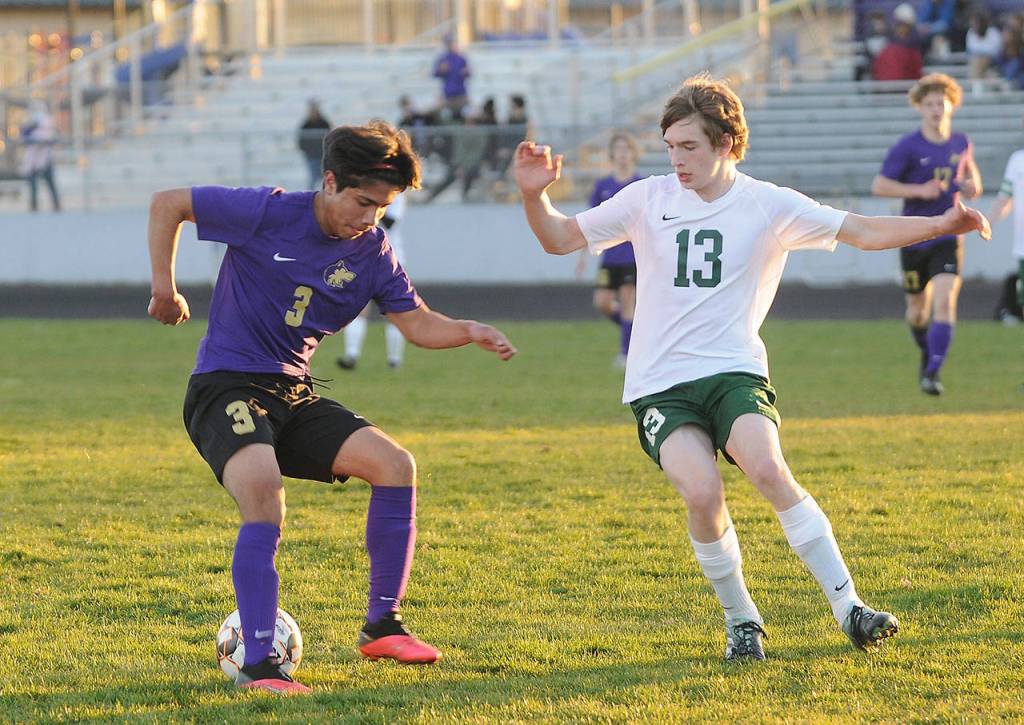 Sequims Cristian Gonzalez, left, looks to make a move past Port Angeles Josiah Long in the Wolves 2-0 home-opener win over the Roughriders on March 25. Sequim Gazette photo by Michael Dashiell