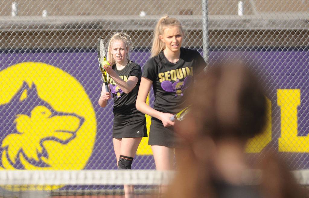 Sequim High senior McKenna Hastings, left, prepares to serve as she and sophomore sister Kendall Hastings take on a North Mason squad on March 29 in Sequim. Sequim Gazette photo by Michael Dashiell
