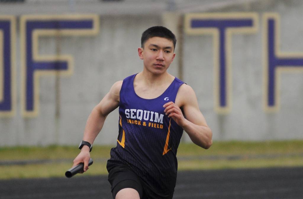 Sequims Koda Robinson competes in the 4x400 relay in the Wolves season-opening meet against Olympic on March 24. Sequim Gazette photo by Michael Dashiell