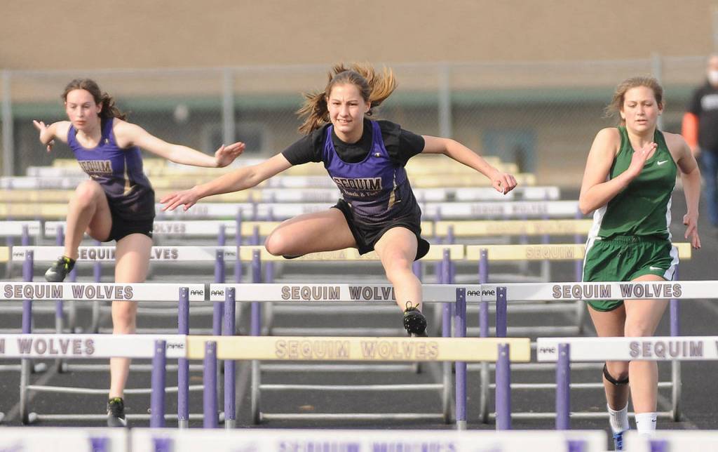 Sequim freshman Taryn Johnson on March 31 races to a win in the 100-meter hurdles with teammate Rileigh VanDyken, left, and Port Angeles Gracie Kennedy trailing. Johnson finished in a personal best 19.71 seconds. Sequim Gazette photo by Michael Dashiell