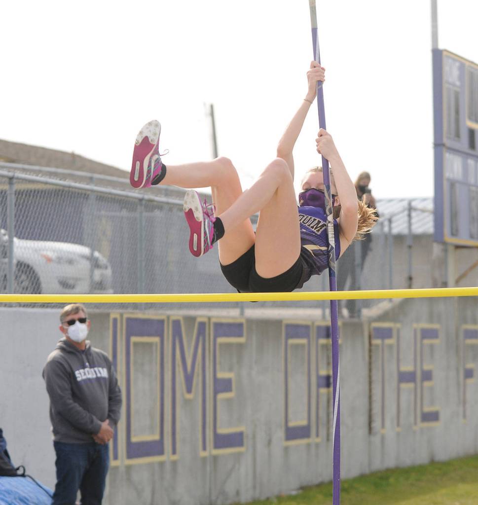 As Sequim head coach Brad Moore watches, Sequim freshman Jolene Vaara clears a height in the pole vault on March 31. Vaara won three events at Sequims March 31 home meet: the pole vault (7-0), high jump (4-10) and long jump (11-10.5). Sequim Gazette photo by Michael Dashiell