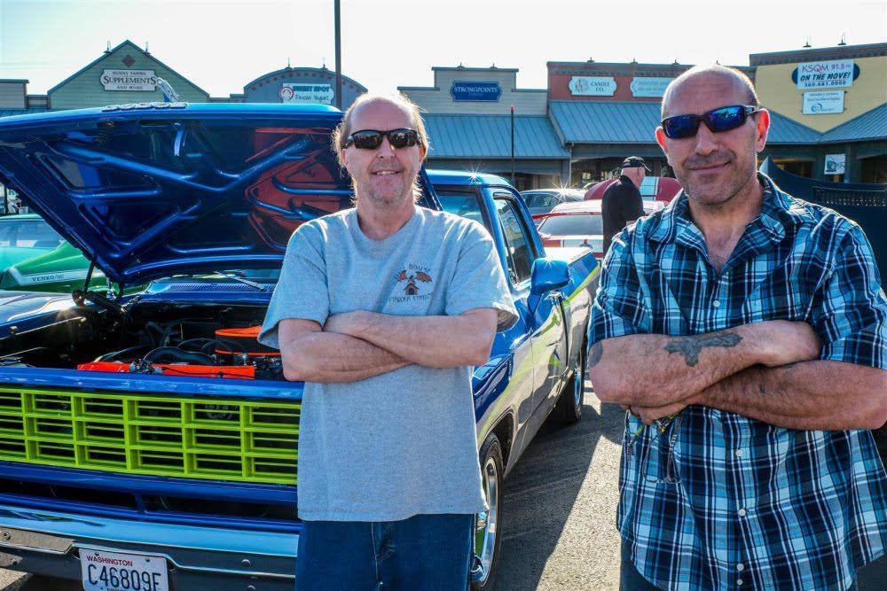 At right: Co-producers Steve Harwood and Lynie Staus enjoy a sunny day for a car show at Sequim Village Center on April 17, including a refurbished 1956 Chevrolet (bottom right) and a number of Cobras (bottom left). Photos by Bob Lampert