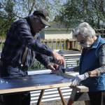 Gardeners Bob Caldwell and Sue Scott work together on April 17 to build one of the walls of a raised bed in the Fir Street Community Garden. Sequim Gazette photo by Matthew Nash