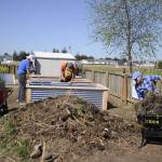 John Anzalotti and Bruce Barden work together to build a raised bed as Jaimi Primrose gathers compost for the new bed at the Fir Street Community Garden. Sequim Gazette photo by Matthew Nash