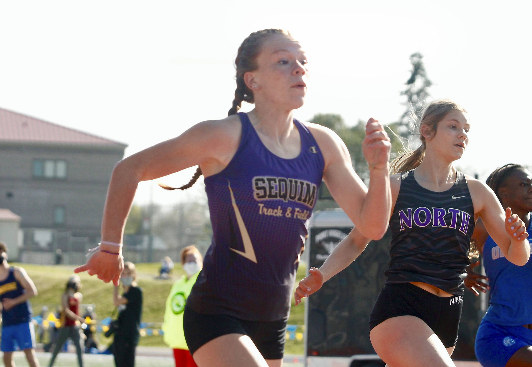 Sequims Riley Pyeatt runs neck-and-neck with Lillian Pruden of North Kitsap in the 100-meter race. She finished second in the 100 but set a school record time in the 400 at the Class 1A/2A/3A Olympic League Championships at Bremerton High School on April 22 and 24. Photo by Mark Krulish/Kitsap News Group