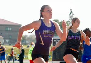 Sequims Riley Pyeatt runs neck-and-neck with Lillian Pruden of North Kitsap in the 100-meter race. She finished second in the 100 but set a school record time in the 400 at the Class 1A/2A/3A Olympic League Championships at Bremerton High School on April 22 and 24. Photo by Mark Krulish/Kitsap News Group