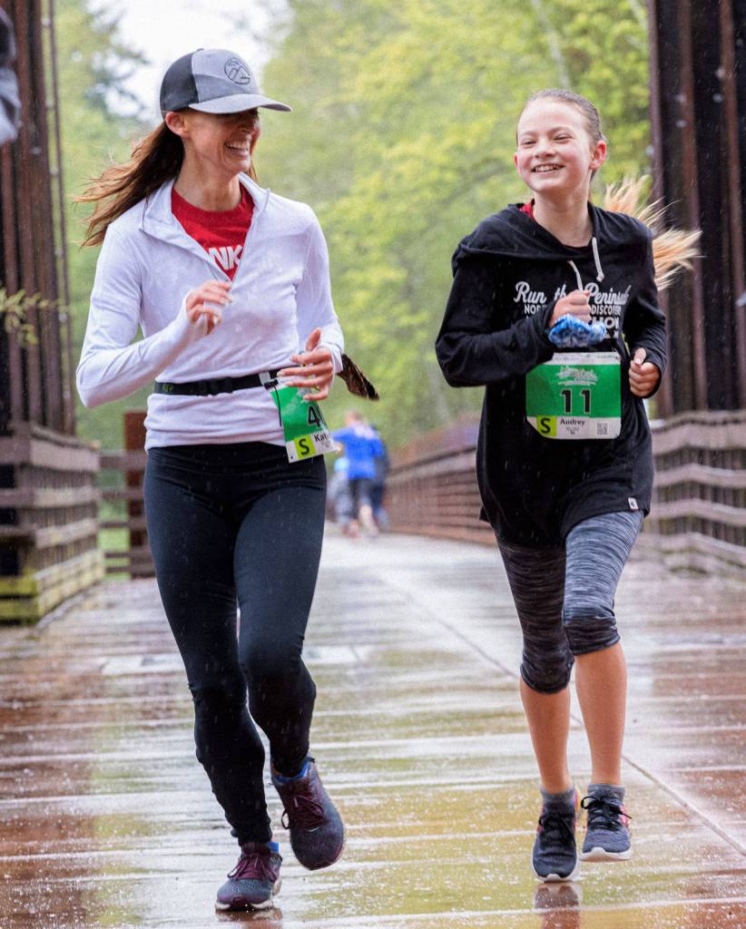 Above: Mother-daughter racers Katie and Audrey Rudd of Port Angeles cross the historic Railroad Bridge in Sequim at the Run the Peninsula Railroad Bridge 5k/10k this past weekend. Left:From 8 to 88: Roan Curran gets a visit from fellow Sequim runner Chuck Milliman at the end of the Railroad Bridge 10k run on April 24.