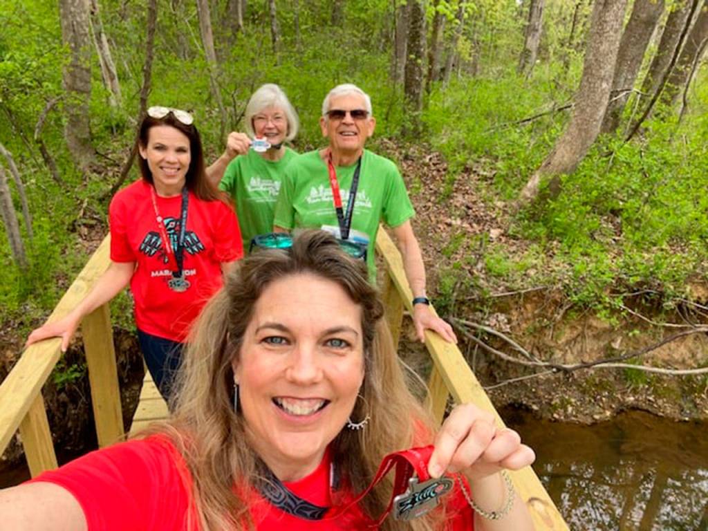 Virtual runners Prentice and Forester of Stafford, Va., complete their 10K Railroad Bridge walk with their daughter on a bridge over a creek on their property. Submitted photo