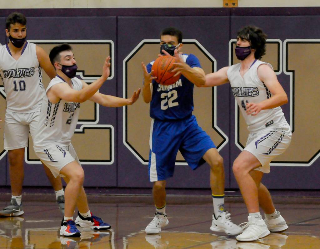Sequims Jayden Possin, second from left, and Cole Smithson, right, poke the ball away from an East Jefferson player in the Wolves 64-40 win on May 10. Sequim Gazette photo by Michael Dashiell