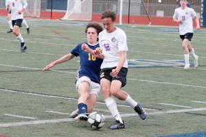 Sequim's Ethan Anderson evades a tackle from Bainbridge's Wyatt Friedman during the Olympic League boys soccer championship on April 28. Photo by Mark Krulish/Kitsap News Group